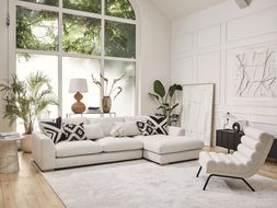DFS Calix right hand facing large chaise end sofa in in ivory boucle, Calix pattern large square footstool, and Calix ripple accent chair in ivory boucle